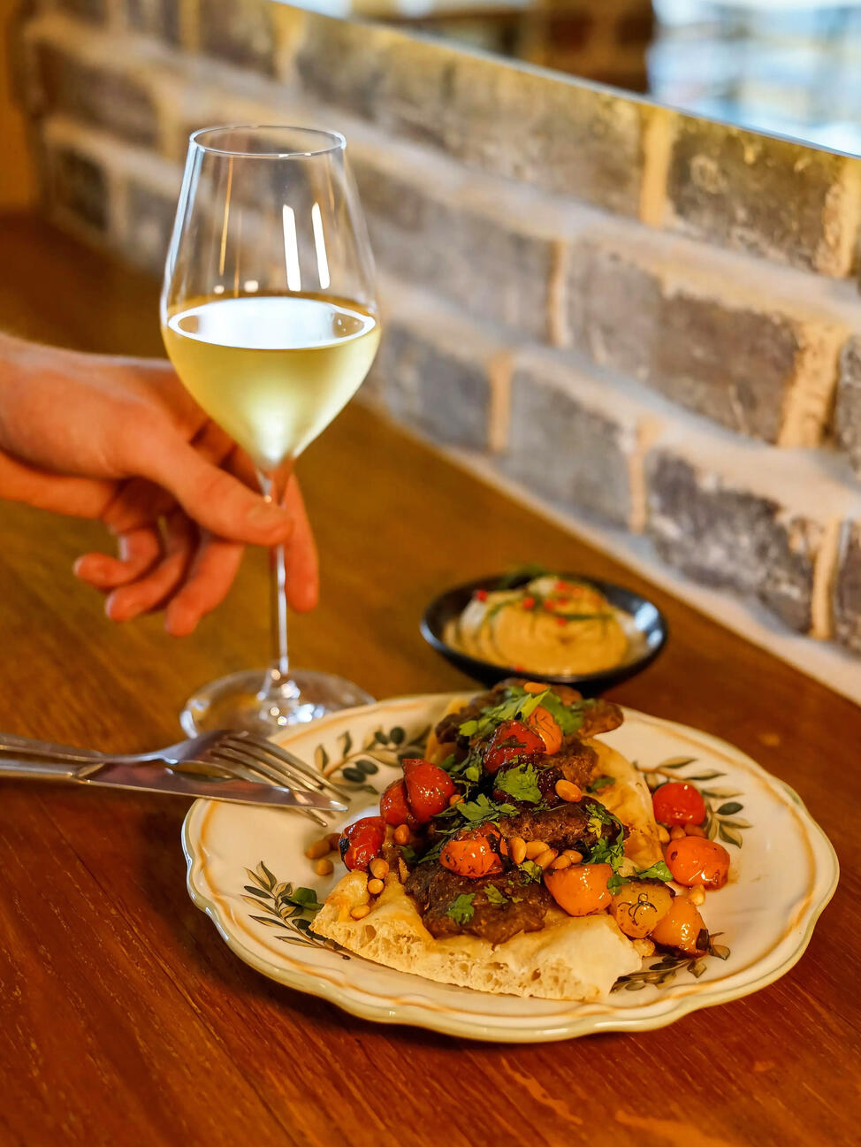 Verre de vin blanc bio ou naturel accompagné d’un plat méditerranéen chez Néroli à Paris 11